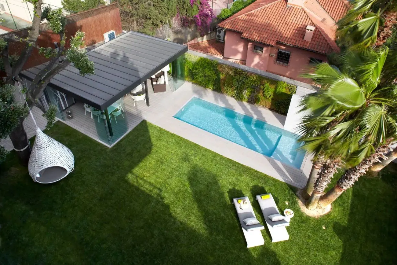 Jardín con césped, jardín vertical, porche acristalado y piscina, trabajo de Sector Natura