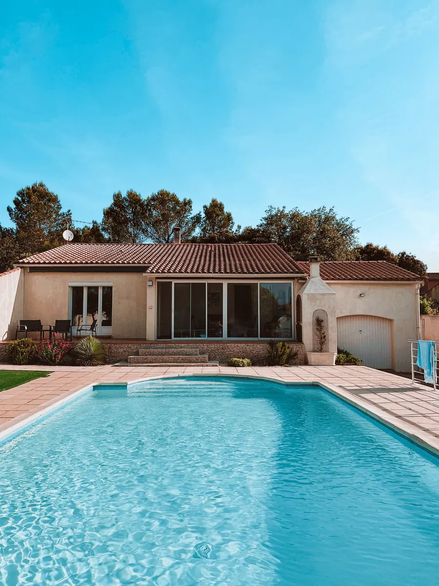 Piscina de fibra delante de una casa de estilo mediterráneo